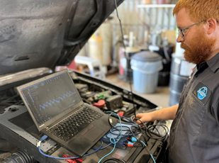 Technician performing vehicle electrical diagnostics