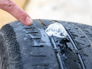 Technician inspecting a tire puncture and performing a safe repair